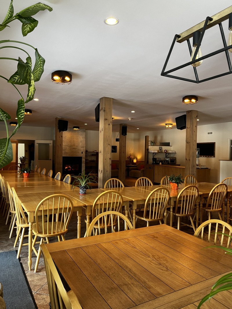 Salle à manger configurée pour un groupe de 40. Une grande tablée de 30 en L et une tablée de 10