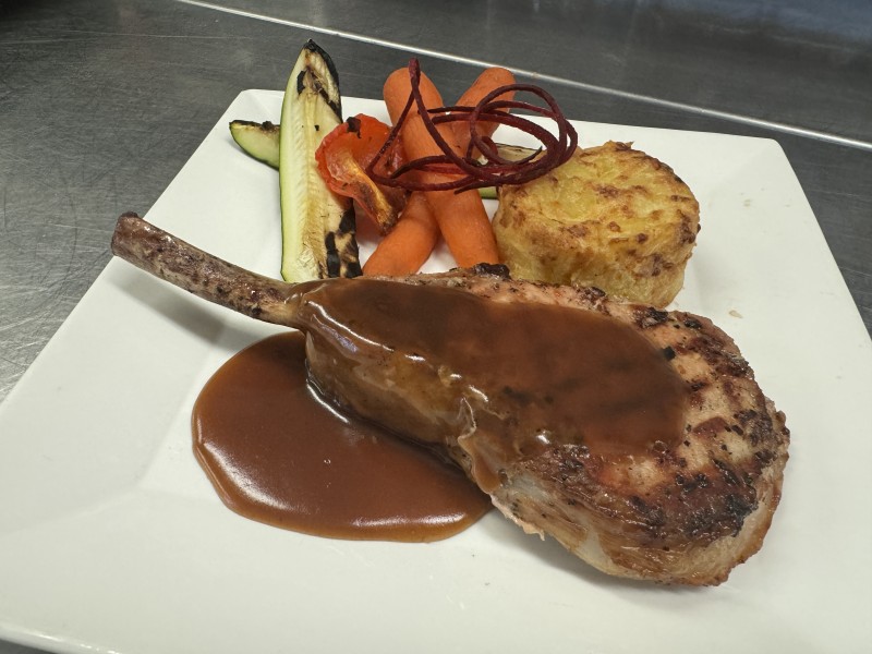 Tomahawk de porc nagano au vin rouge, épice cajun et gelée d'abricot